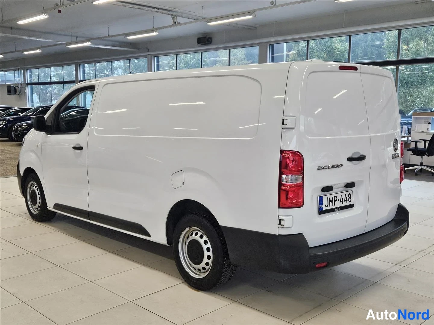 Takaviisto: Fiat Scudo -pakettiauton takakulma oikealta valkoisena autohallissa, rekisteritunnus.