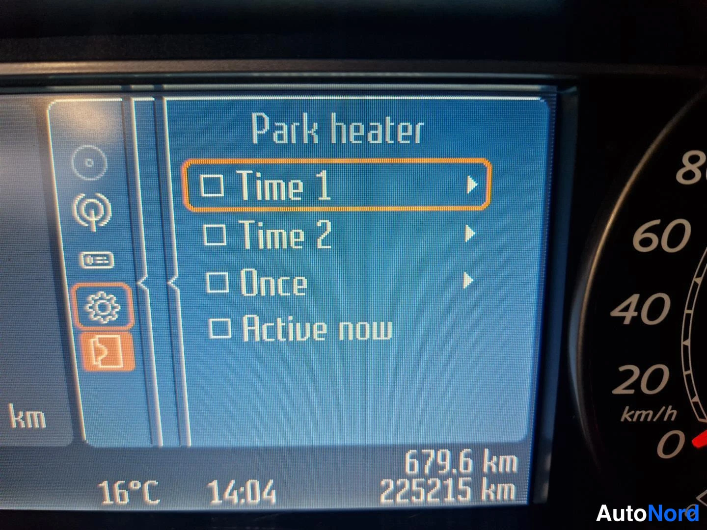 Etuviisto, nokka vasemmalle: Kojelaudan näyttö näyttää Park heater -valikon: Time 1, Time 2, Once, Active now. Kuljettu matka 225 215 km, kellonaika 14:04, lämpötila 16 °C.