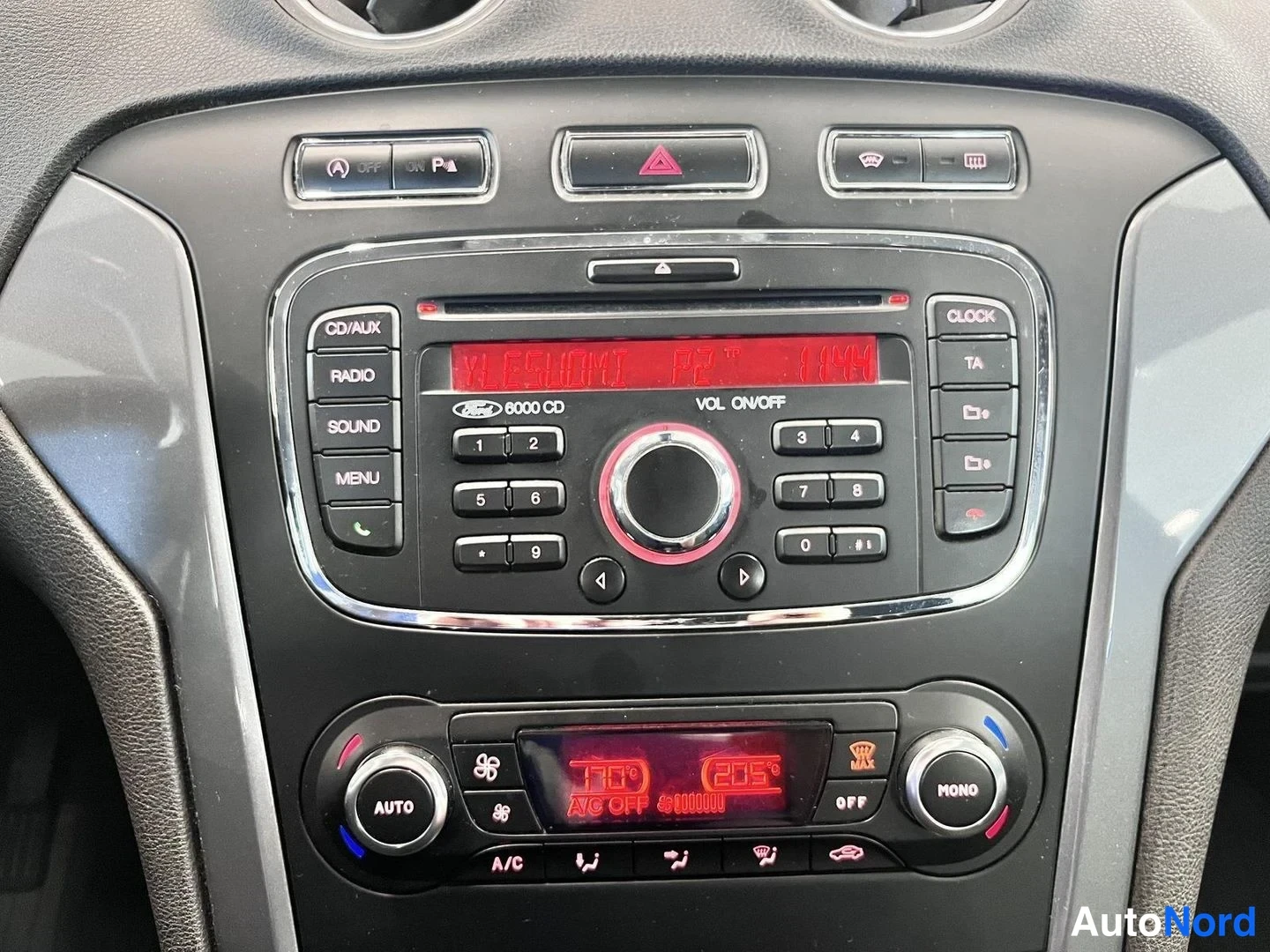 Yksityiskohta: Keskiöikunnan Ford 6000 CD -radioyksikkö CD/AUX-, RADIO-, SOUND- ja MENU-painikkeilla, taustalla red lämpötilapainikkeet ja ilmastointipaneeli AUTO- ja MONO-kyt