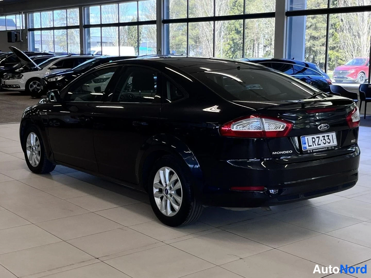 Takaviisto: Mustan Ford Mondeon takakulma oikealta; takaosassa Mondeo-teksti ja rekisteritunnus.