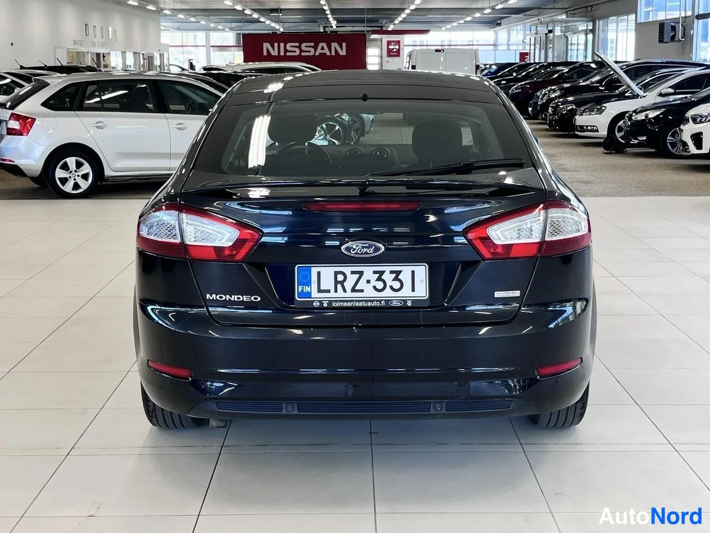 Takaa: Mustan Ford Mondeon takaosa suoraan takaa; rekisterikilpi.