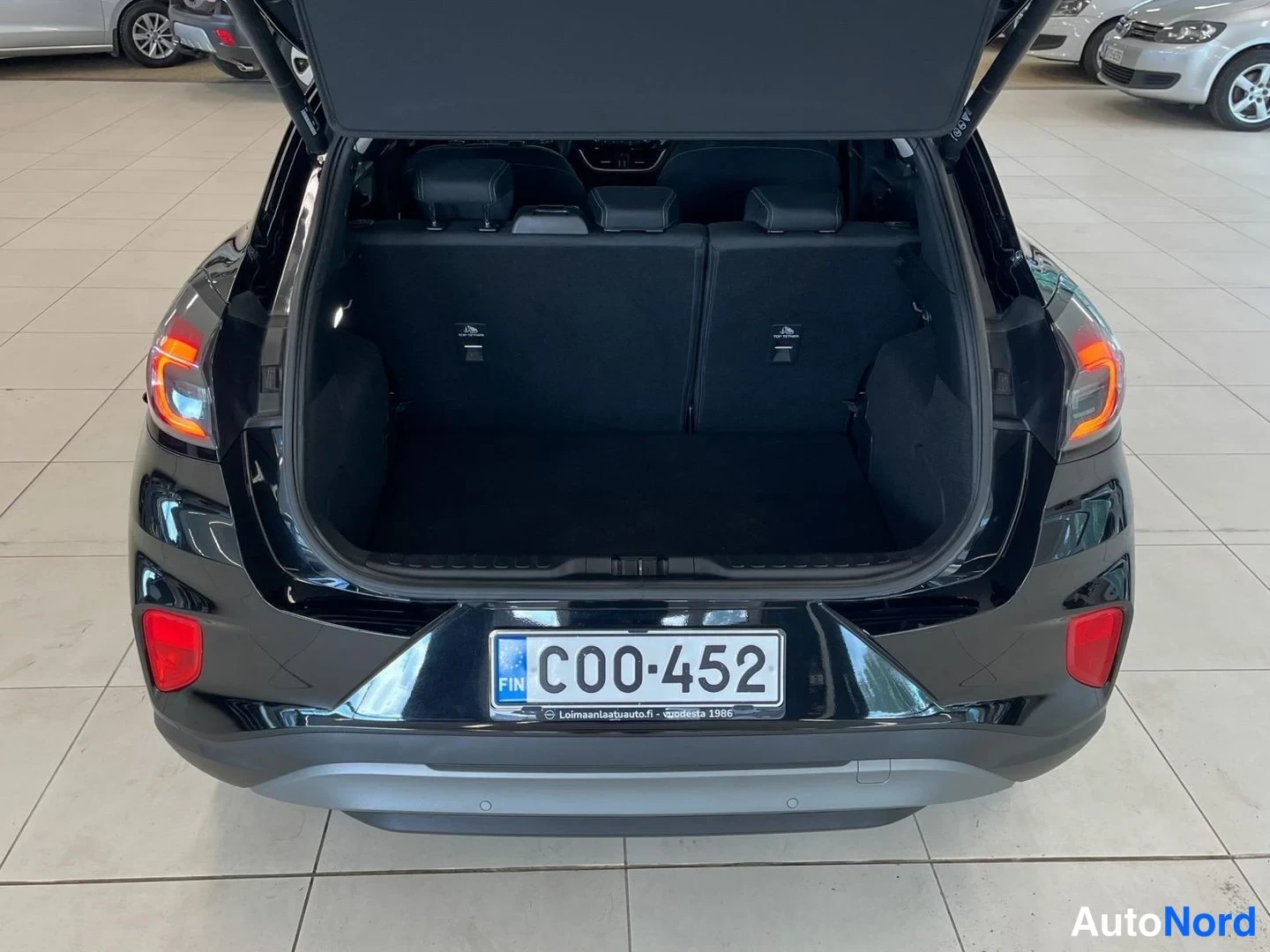 Takaa: Mustan Ford Puman avattu takaluukku ja tavaratila.