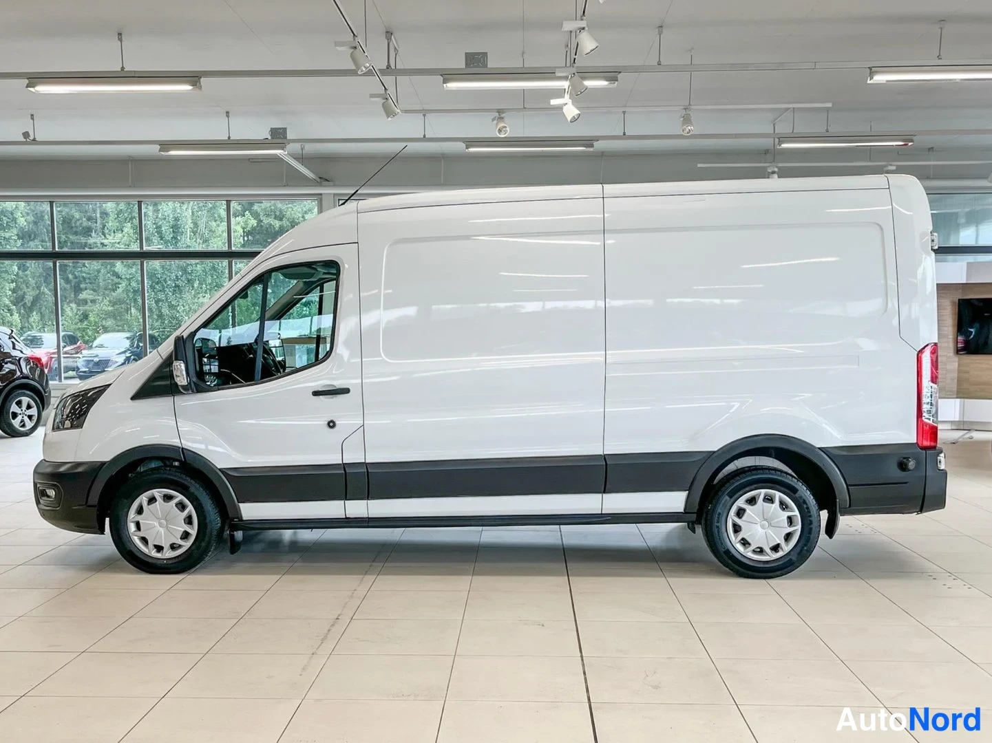 Etuviisto, nokka vasemmalle: Valkoinen pakettiauto sivulta ja etukulmasta sisätiloissa.