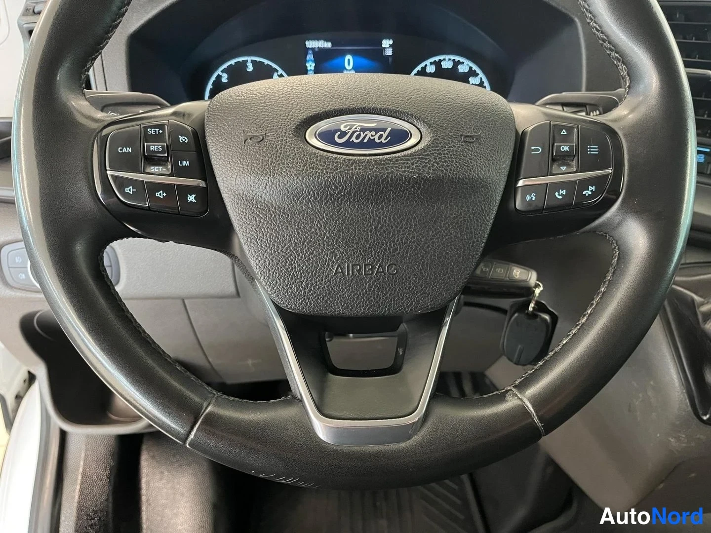 Muu: Lähikuva Ford-ohjauspyörästä, jossa AIRBAG-merkintä, monitoiminapit molemmin puolin ja avainvirta tiedossa kojetaulussa 0 km/h.