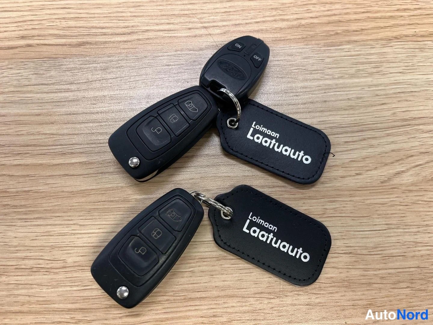 Muu: Kaksi avainnipua pöydällä; kaukosäätimet ja Loimaan Laatuauto -avainnimikkeet.