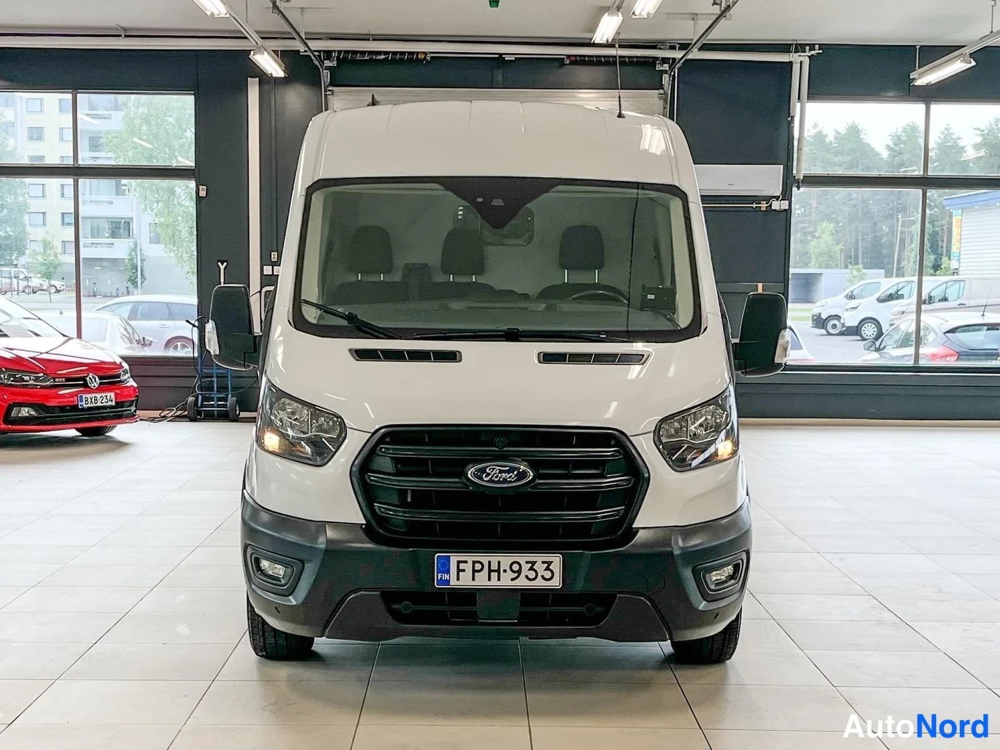 Edestä: Valkoinen pakettiauto etukatselussa; rekisterikilpi ja Ford-merkki jäähdyttimeen säleikössä.