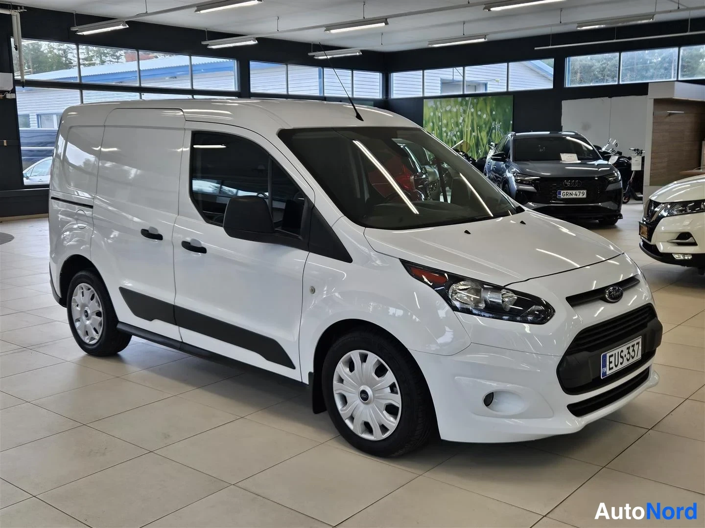 Etuviisto, nokka oikealle: Valkoinen Ford Transit Connect -pakettiauto etukulmasta oikealta, rekisteritunnus.