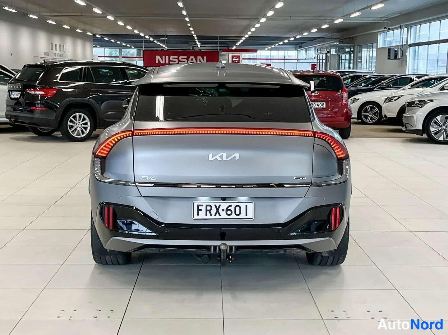 Takaa: Auton takaosa myymälässä: Kia-logo, EV6- ja GT-merkinnät, rekisteritunnus, poikittainen takavalopalkki ja vetokoulukoukku.