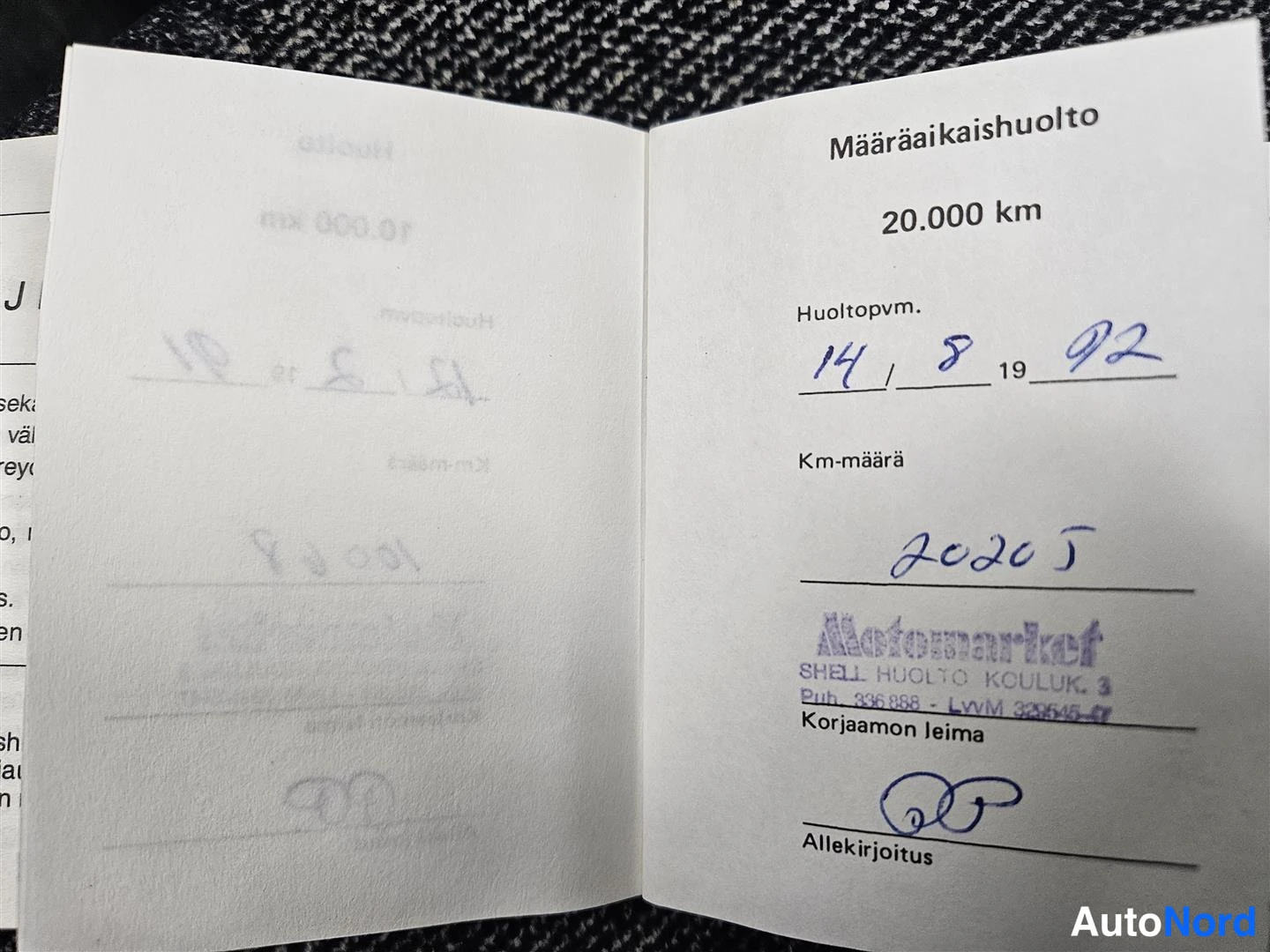 Muu: Huoltokirja avattu Määräaikaishuolto 20.000 km -sivulle; käsinkirjoitettu päivämäärä 14/8 1992, mittarilukema 20205 km ja Motomarket Shell Huolto Kouluk. 3 -lei