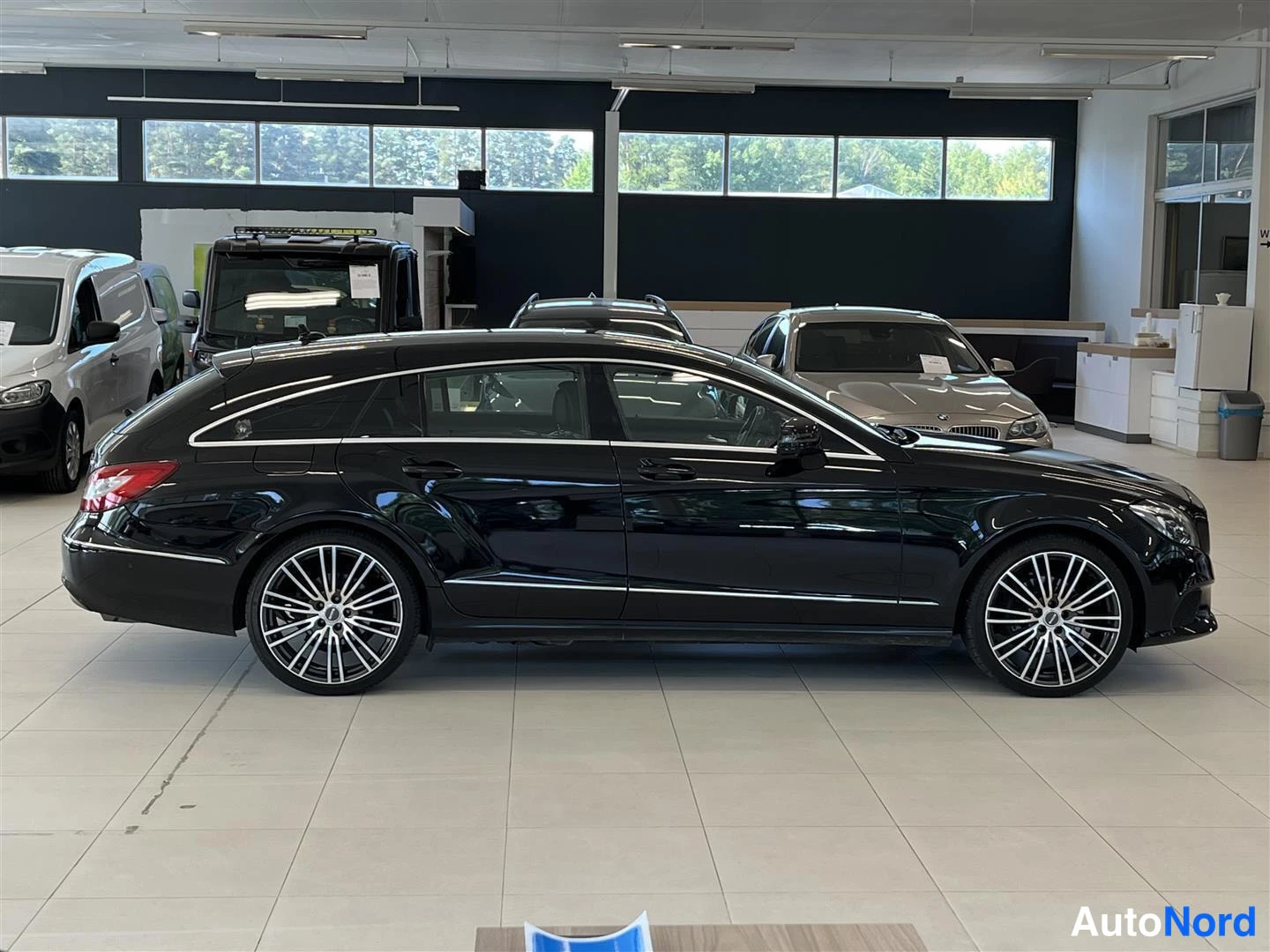 Sivulta: Mustan Mercedes-Benz CLS Shooting Braken sivuprofiili autonäyttelyssä.