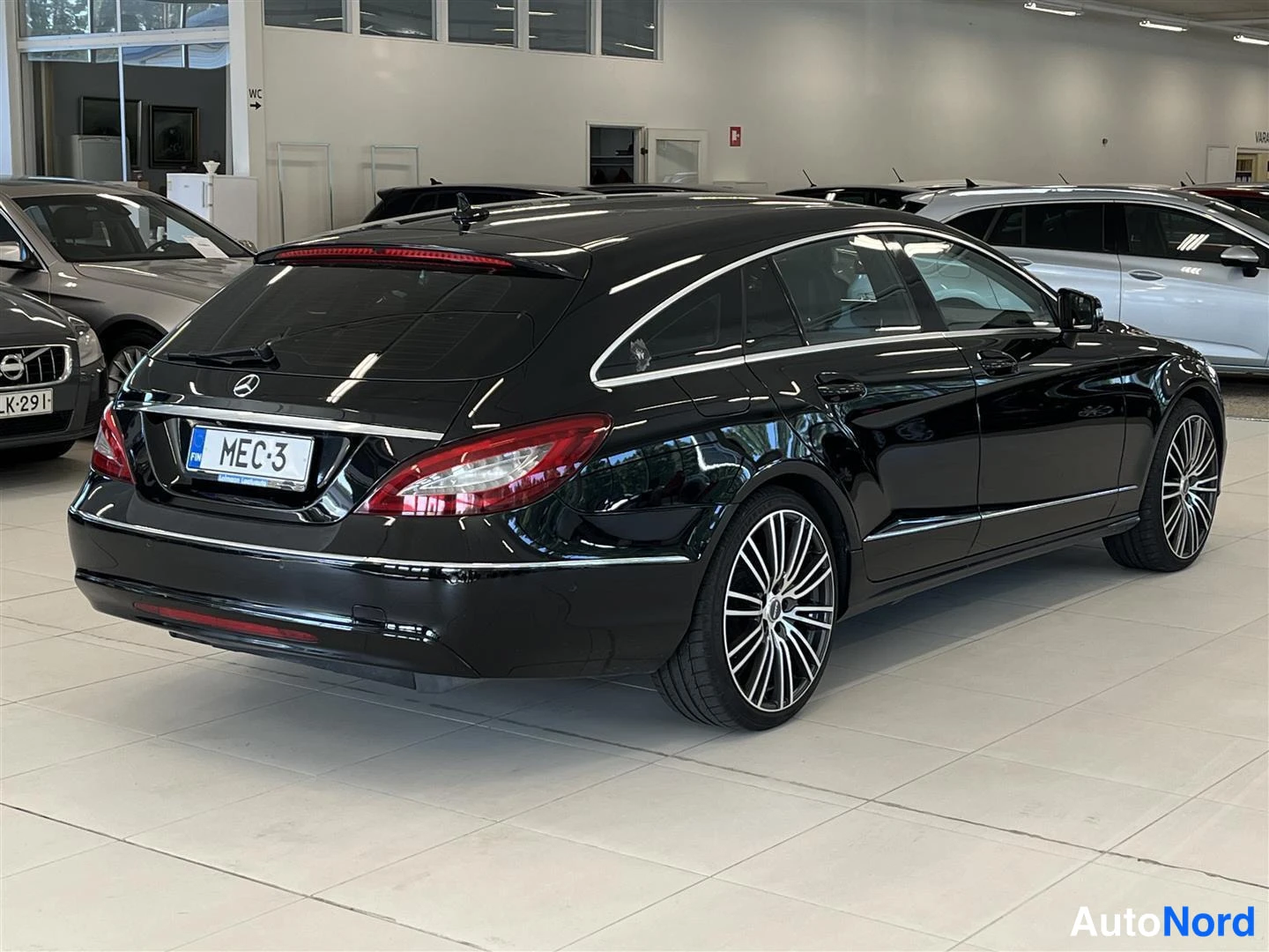 Takaviisto: Musta Mercedes-Benz CLS Shooting Brake takakulmassa autonäyttelyssä, rekisterikilpi.