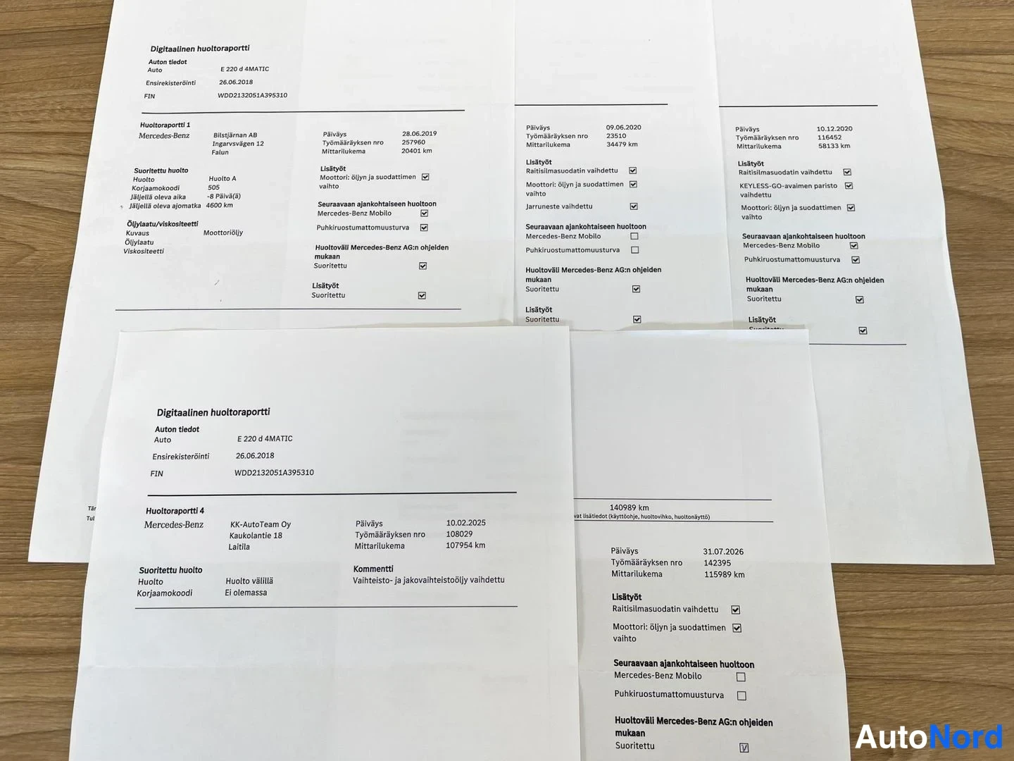 Muu: Pöydällä paperisia digitaalisia huoltoraportteja, joissa Mercedes-Benz E 220 d 4MATIC -auton huoltohistoria.