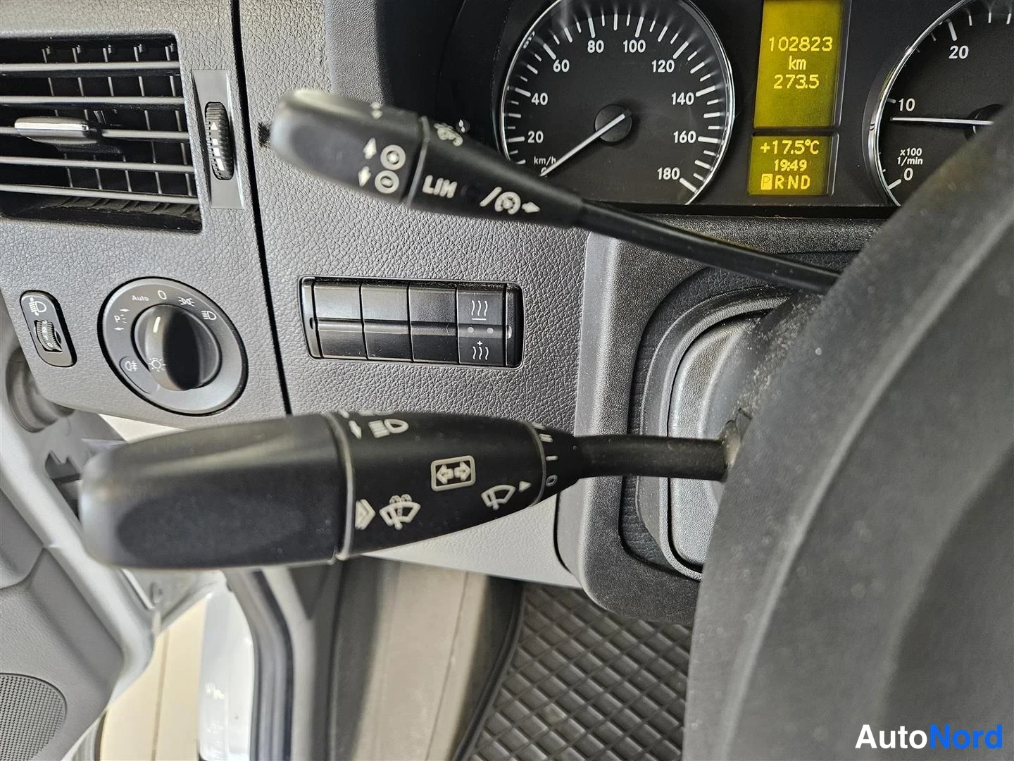 Muu: Mercedes-Benz Sprinter -mittaristo ja ohjaustangot; näytössä 102823 km, 2735 ja RND, nopeusmittari asteikolla 0-180 km/h.