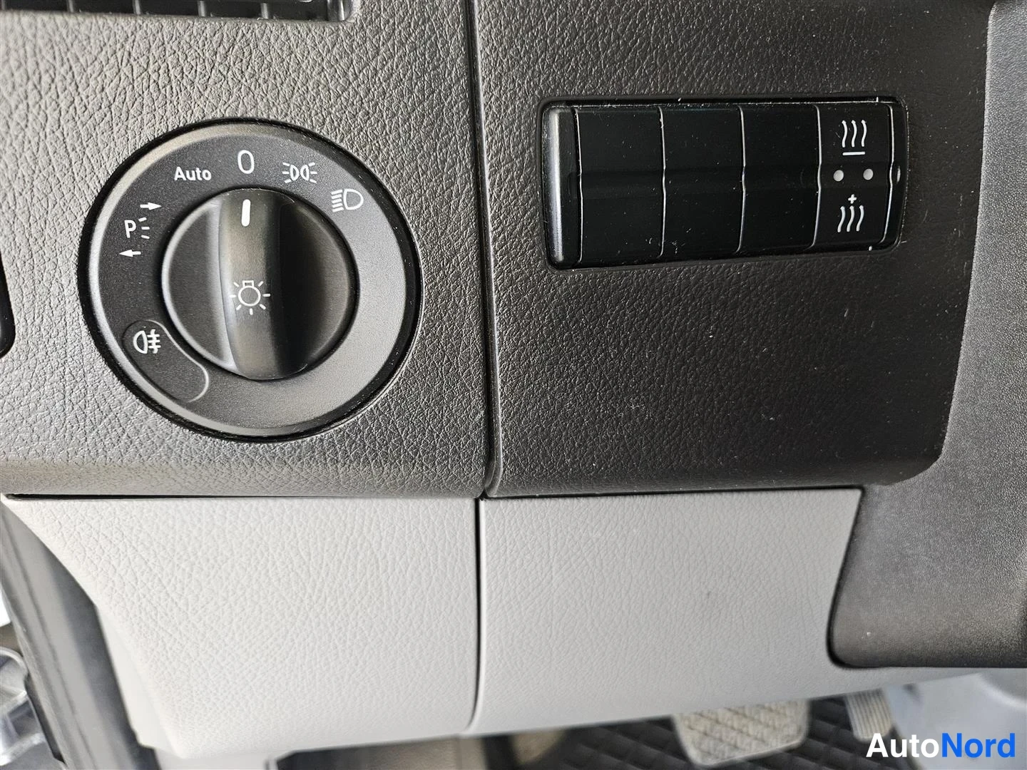 Muu: Kojelaudan valokytkin (Auto, 0, P-symbolit) ja pari liittämis-/lämmityspainiketta mustassa paneelissa.