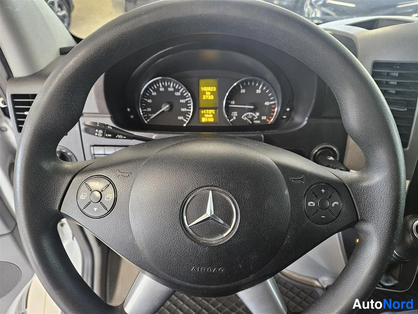Muu: Mercedes-Benzin ratin ja kojelaudan näkymä, mittaristossa lukema 100823 km.