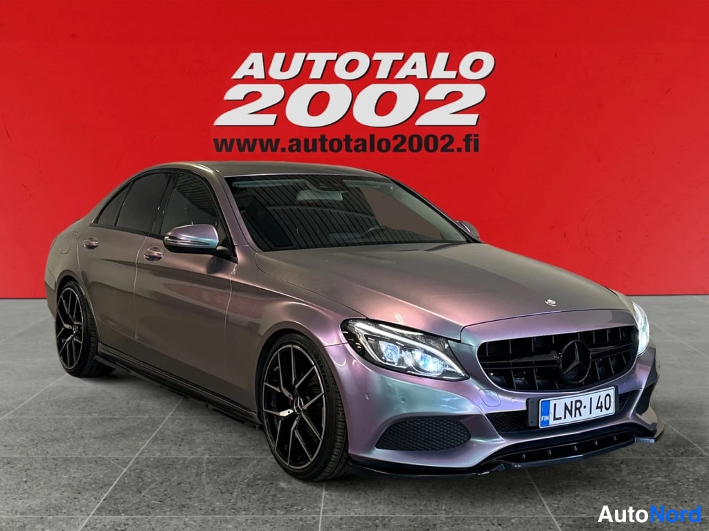 Etuviisto, nokka oikealle: Mercedes-Benz C-sedan etuviisto vasemmalta, vaaleanvioletinharmaa kori, mustat kevytmetallivanteet, rekisteri