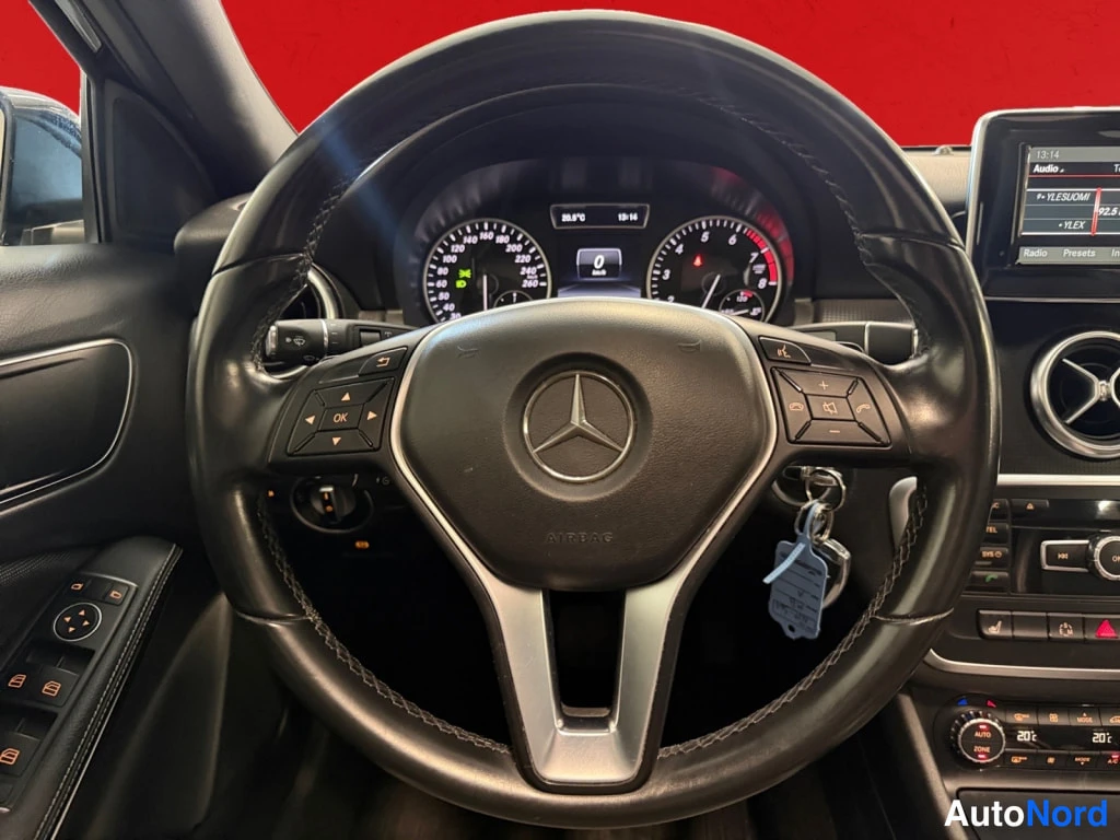 Edestä: Ohjauspyörä ja kojelauta: Mercedes-vakioohjauspyörä, mittarit ja keskikonsolin näyttö sekä avain sytytyslukossa.