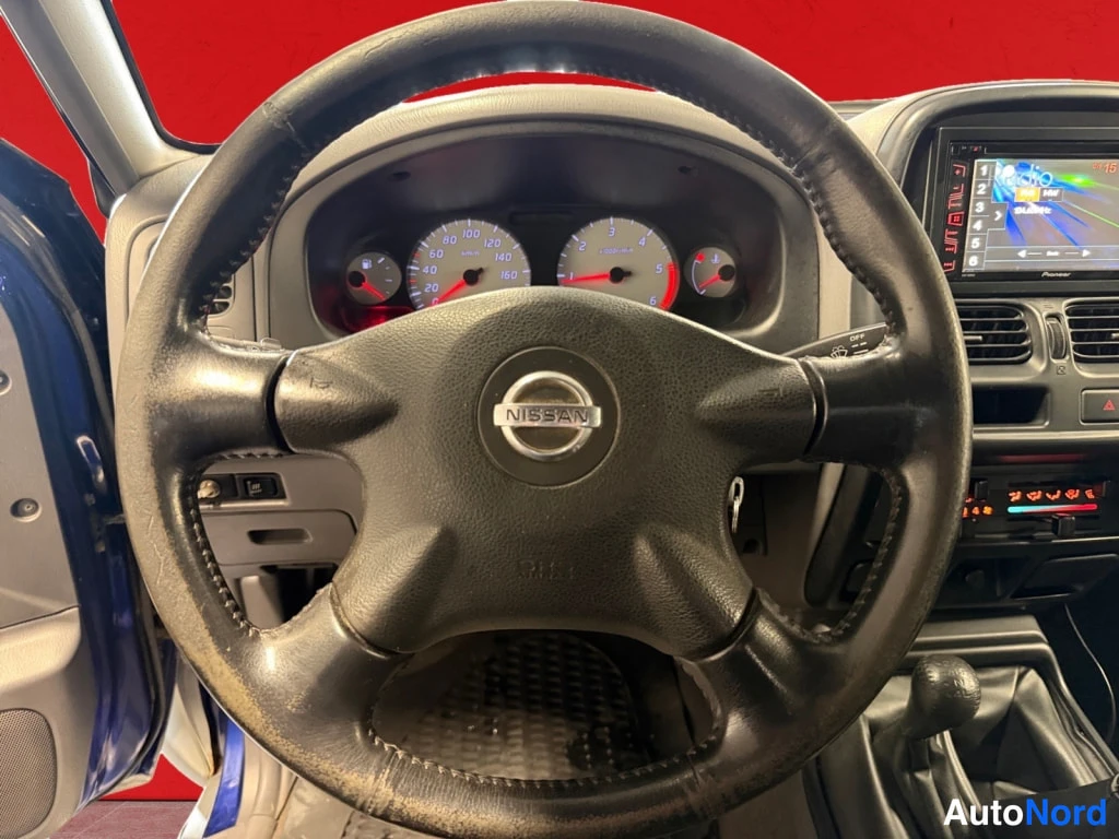 Muu: Ohjaamosta kuva: Nissan-merkitty ohjauspyörä, mittaristo ja Pioneer-radiopaneeli.
