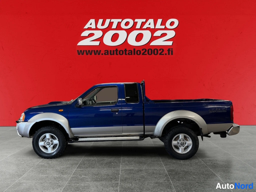 Sivulta: Nissan NP300 -mallin sivukuva; sininen kori ja hopeiset maalatut osat, näkyvissä ovet ja lavan sivu.