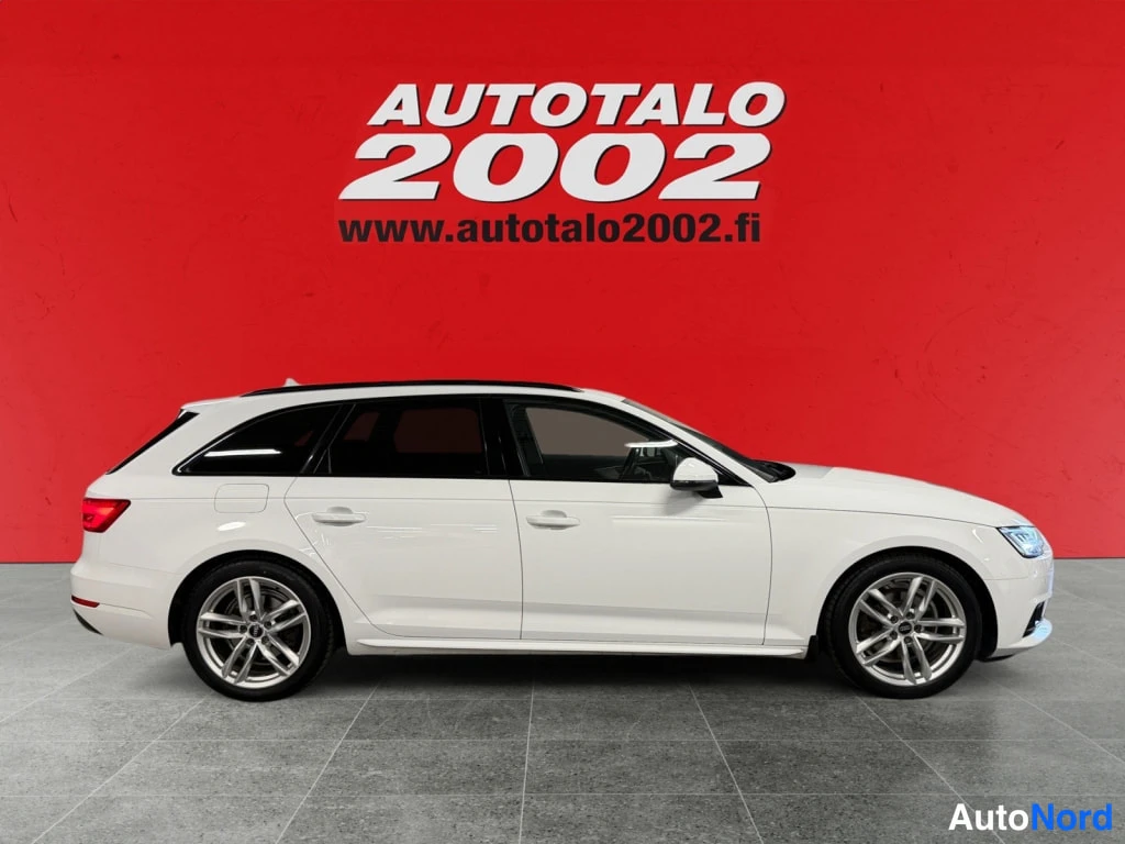 Sivulta: Valkoinen Audi A4 -farmari sivulta oikealta katsottuna punaisella taustalla.