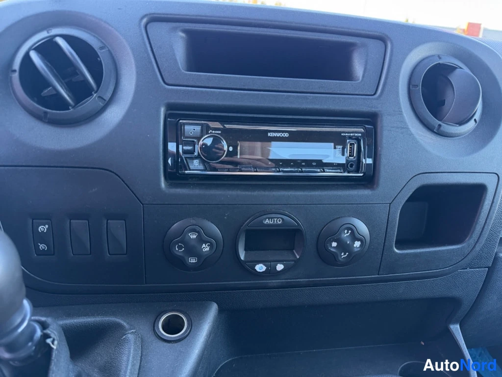 Yksityiskohta: Kojelaudan keskusta: Kenwood-radio USB-liittimellä, automaattinen ilmastointi (AUTO) ja AC/off-painike.
