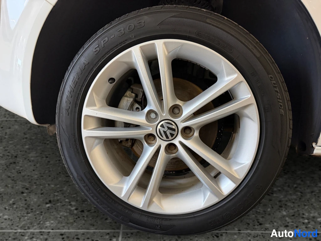 Yksityiskohta: Volkswagenin alumiinivanteeseen kiinnitetty Athena SP-303 -kesärenkaiden sivuseinä, jossa lukee 'OUTSIDE', lähikuva.