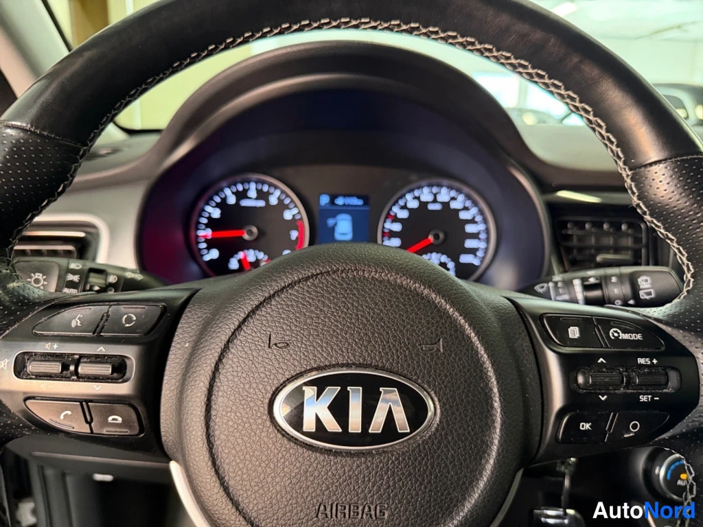Muu: Näyttömön KIA-logolla ja AIRBAG-tekstillä, mittariston tachometri ja nopeusmittari taustalla, ratissa Multimode- ja RES+/SET-napit.