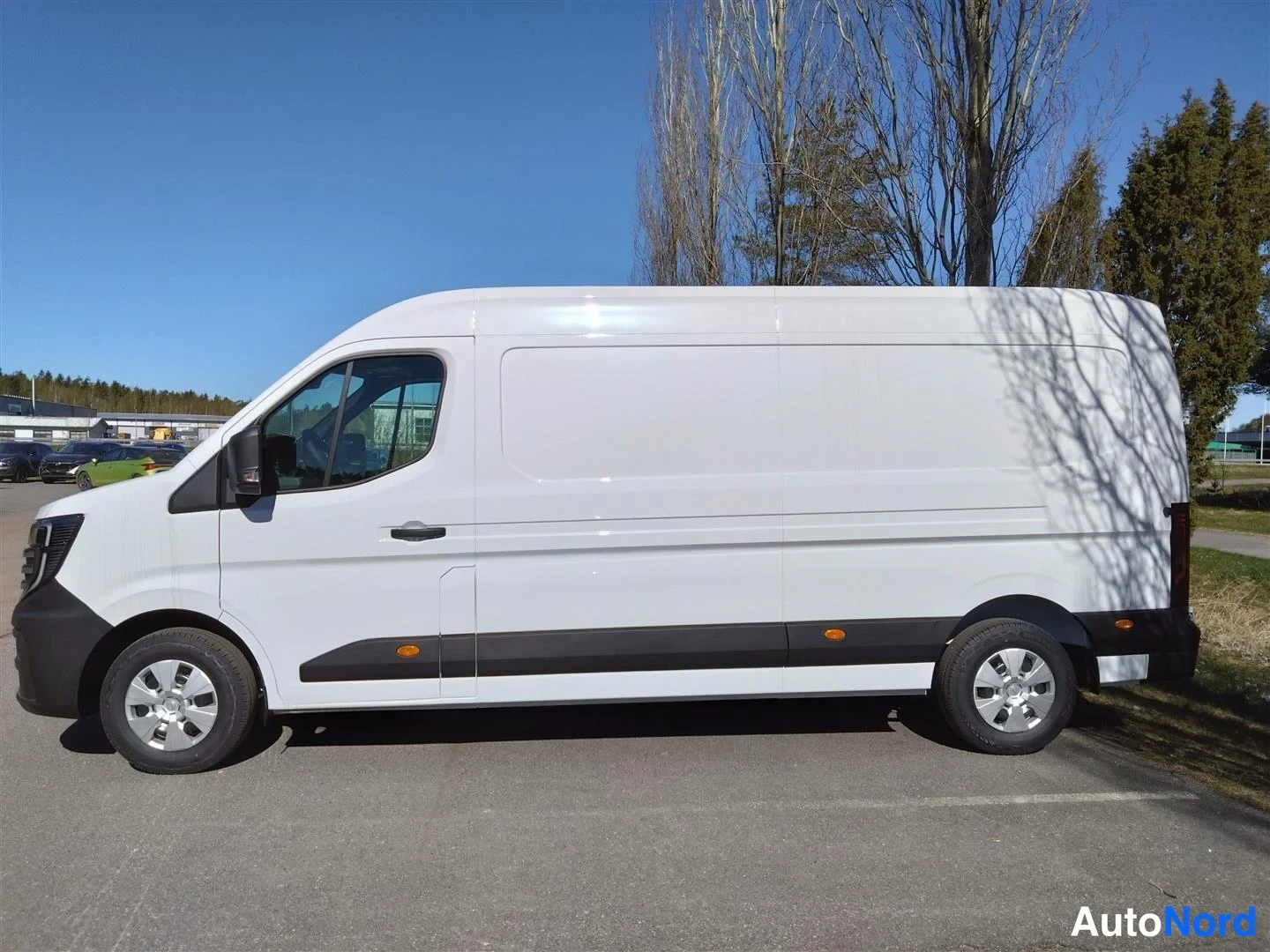 Sivulta: Valkoinen Nissan Interstar -pakettiauto sivulta vasemmalta kuvattuna parkkipaikalla.