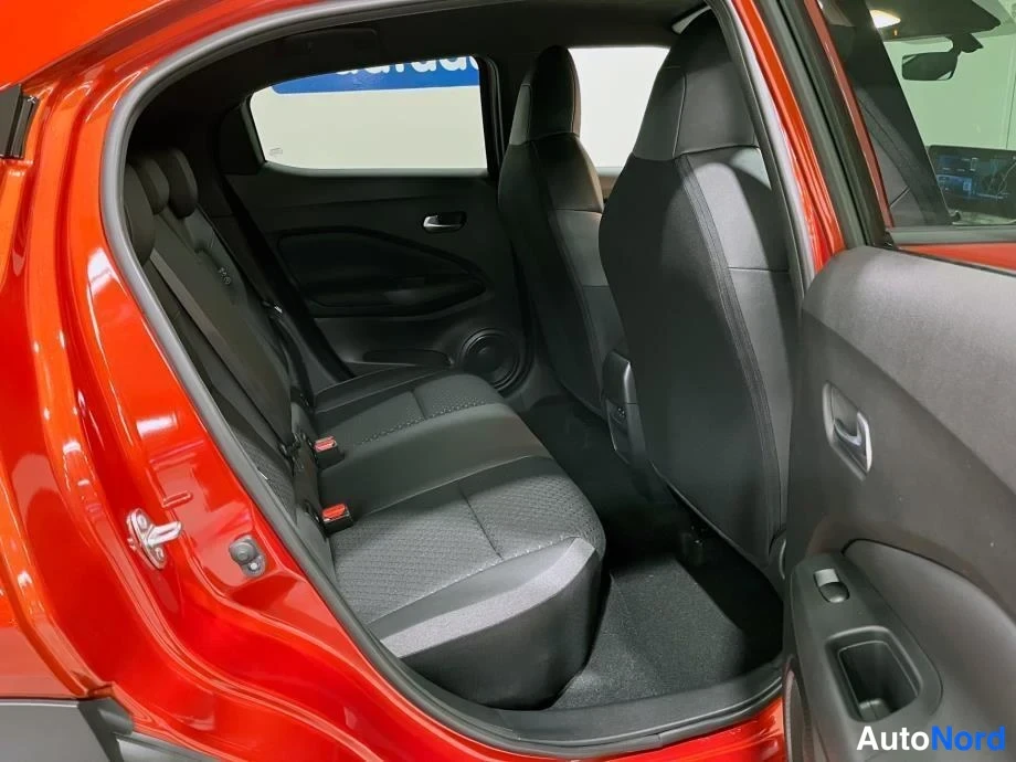 Sivulta: Nissan Juke:n takapenkkijumpan takaa kuvattuna, tummat istuimet ja punainen korimaali näkyvät.
