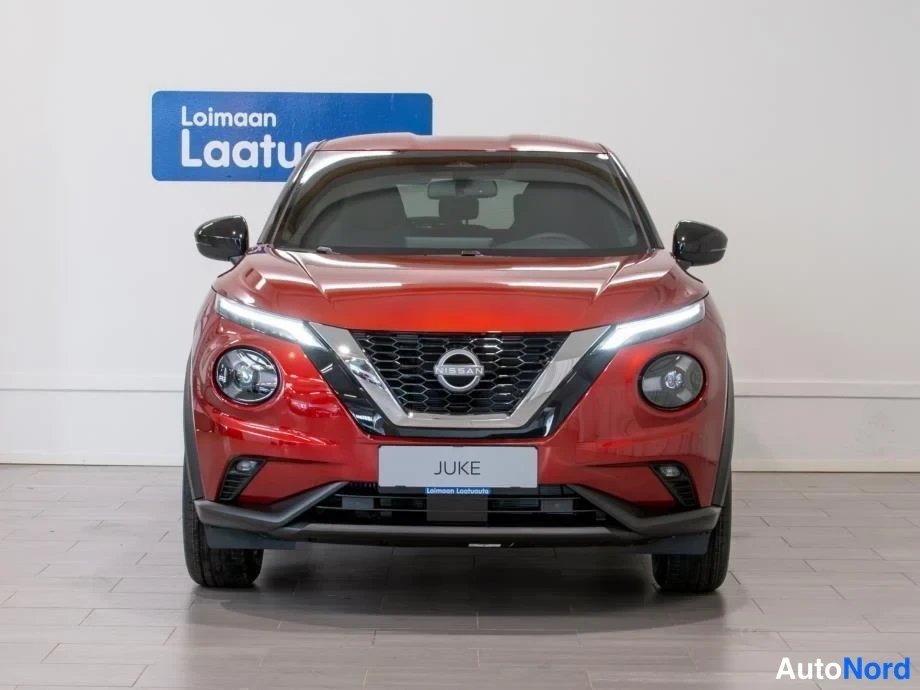 Edestä: Punainen Nissan Juke suoraan edestä kuvattuna, JUKE-teksti etupaneelissa.