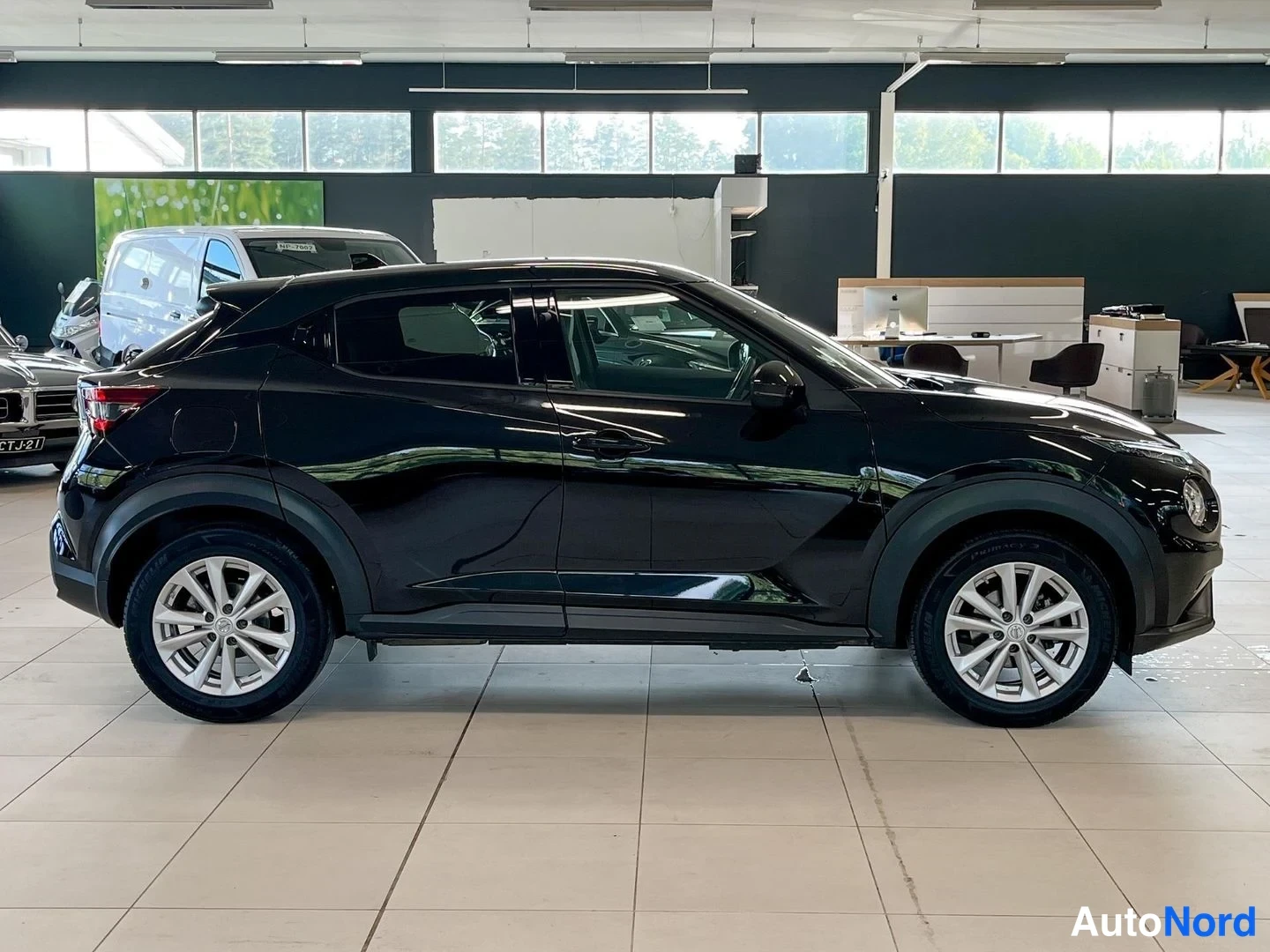 Takaviisto: Mustan Nissan Juke -henkilöauton takakulmanäkymä vasemmalta puolelta showroomissa.