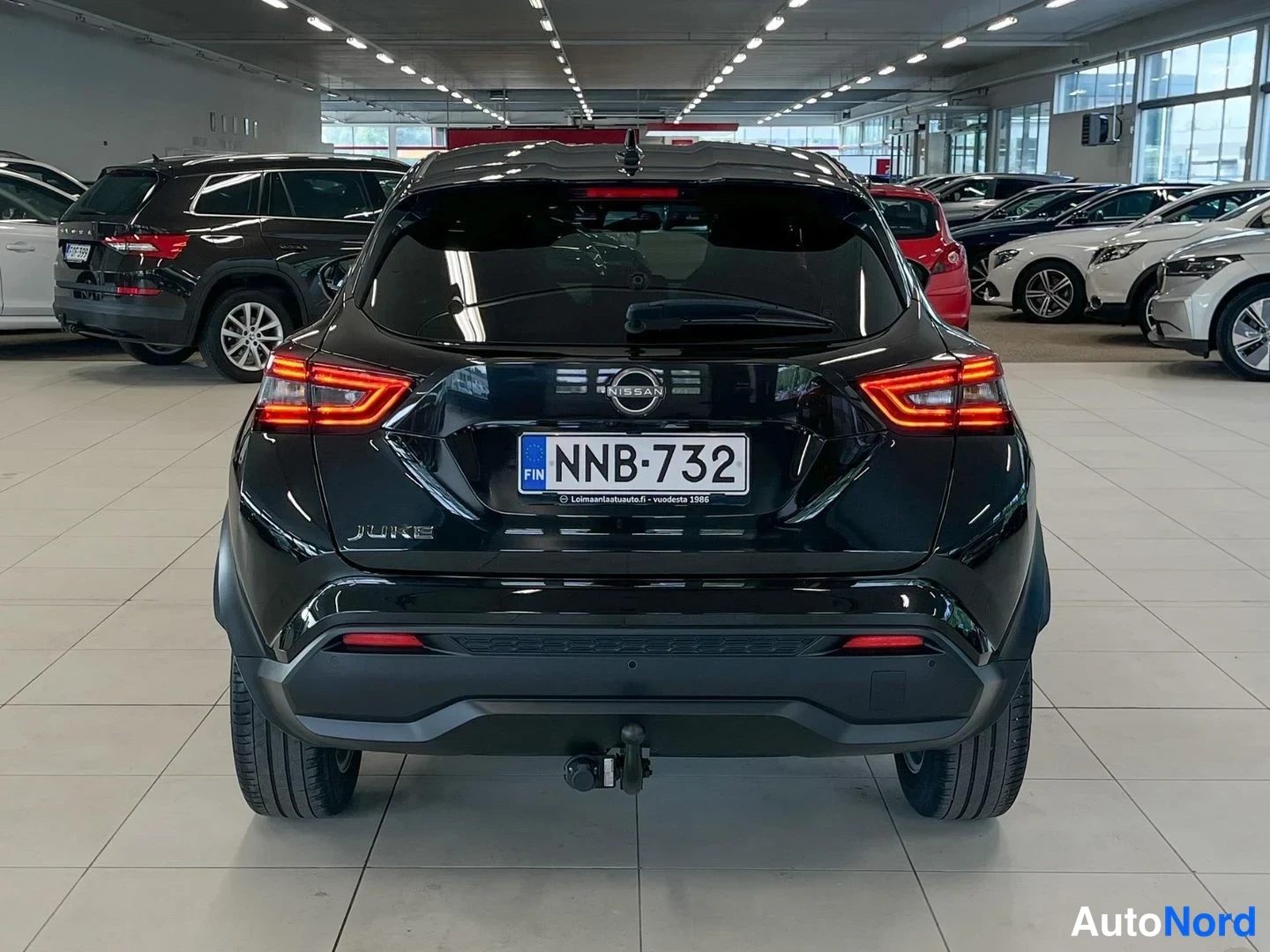 Takaa: Nissan Juke musta takaa kuvattuna; pyyhinjäälukko ja vetokoulu, sisätilassa muuta kalustoa.