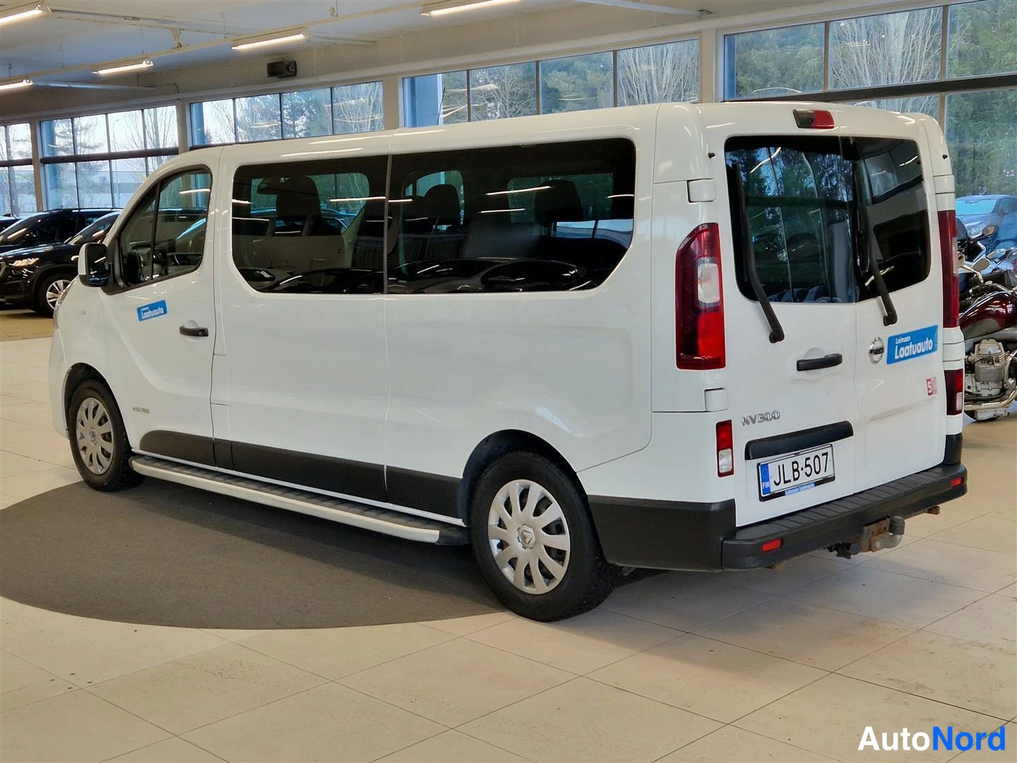 Takaviisto: Valkoisen Nissan NV300 -pakettiauton takaosa ja vasen sivu; takavalot, kylkijalkataudit, rekisterikilpi ja NV300-tunnus näkyvät.