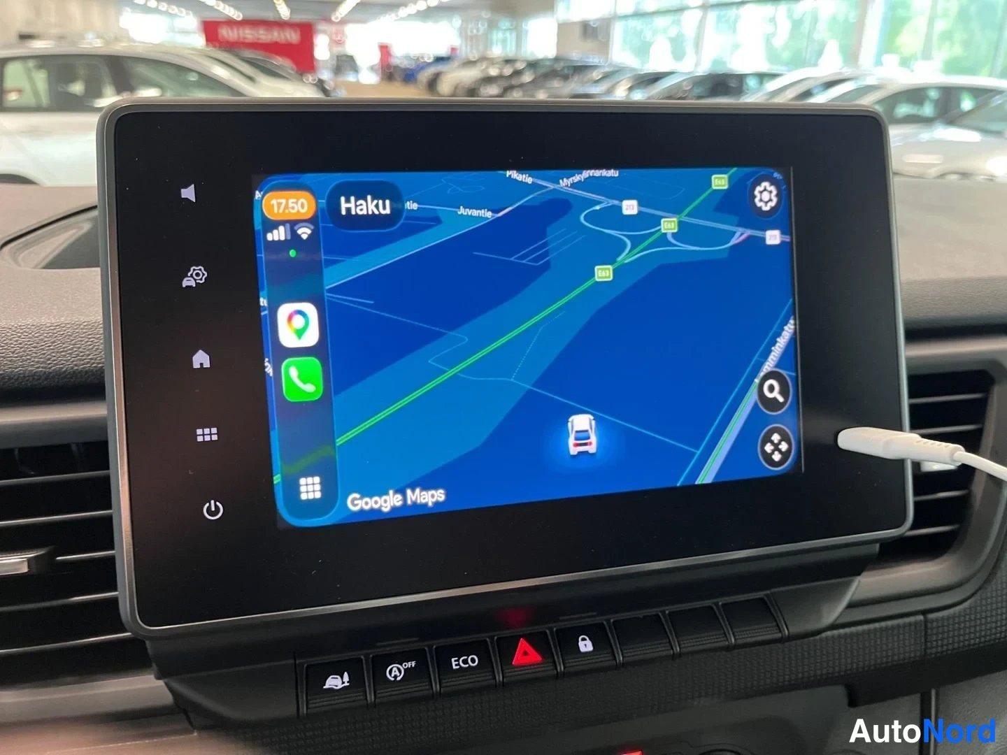 Yksityiskohta: Kojelaudan infotainment-näyttö, jossa on käynnissä Apple CarPlay ja Google Maps -navigaatio