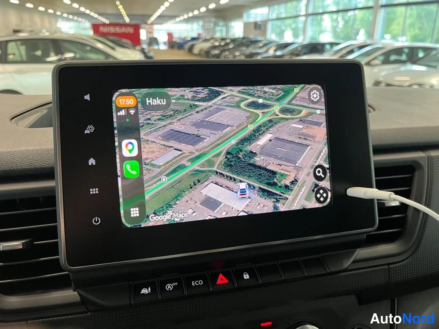 Yksityiskohta: Pysäköintihallissa infotainment-näyttö, jossa Apple CarPlay ja Google Maps -satelliittikartta