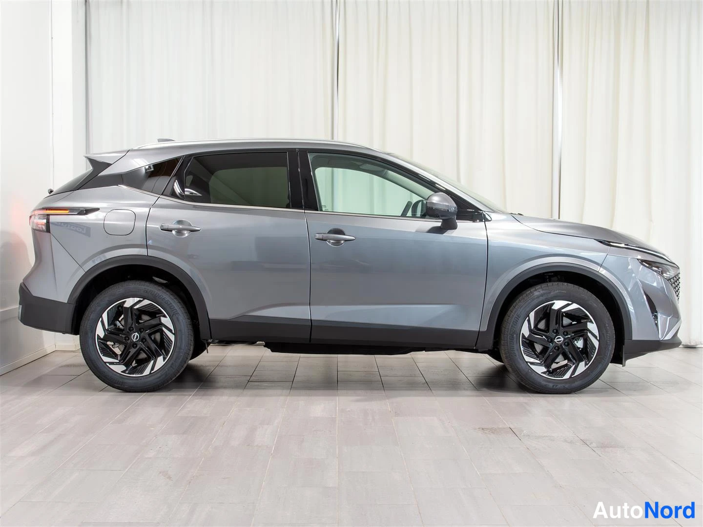 Etuviisto, nokka oikealle: Nissan Qashqai sivuprofiililta oikealta kuvattuna, harmaa maalipinta, konepelti ja etusäleikkö kuvan oikeassa reunassa.
