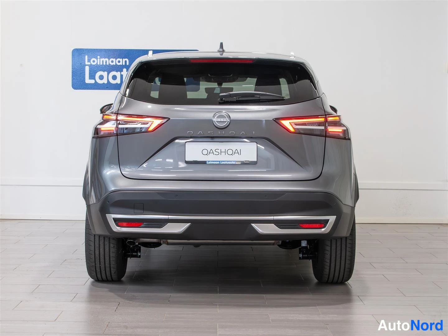 Takaa: Nissan Qashqai suora takanäkymä: pohjavaloiset takavalot, QASHQAI-teksti ja QASHQAI-kyltti kannen läpissä, takapuskurin alareunassa kromilistat.