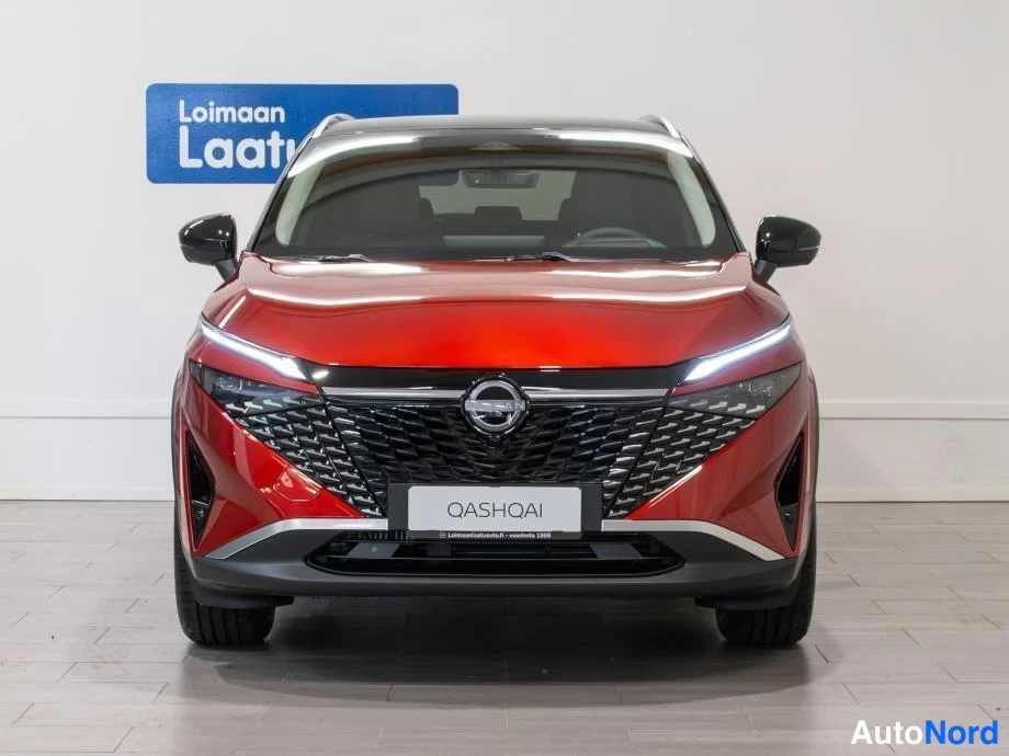Edestä: Punaisen Nissan Qashqain etupää kohti kameraa, Nokia-kenkään ja tumma konepelti näkyvät kuvassa