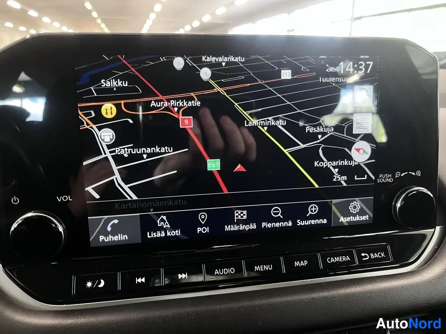 Muu: Auton infotainment-näyttö, jossa kartta ja navigointivalikot, kellonaika 14:37.