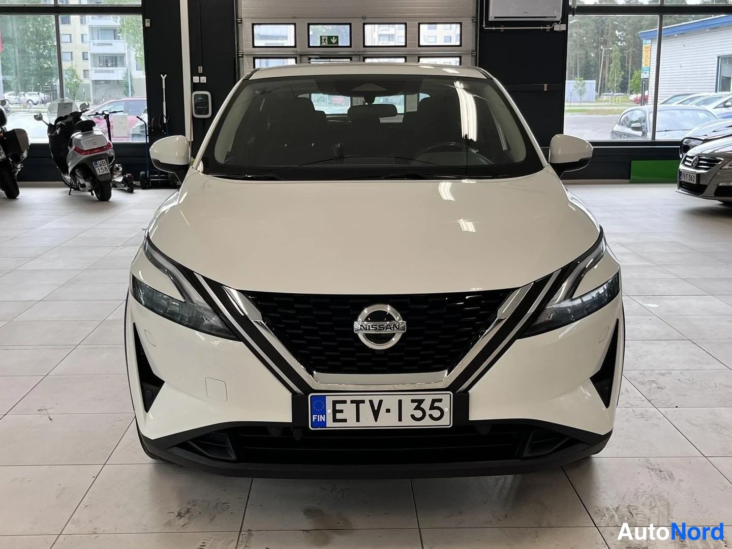 Edestä: Valkoinen Nissan Qashqai suoraan edestä päin autotallissa, rekisterikilpi.