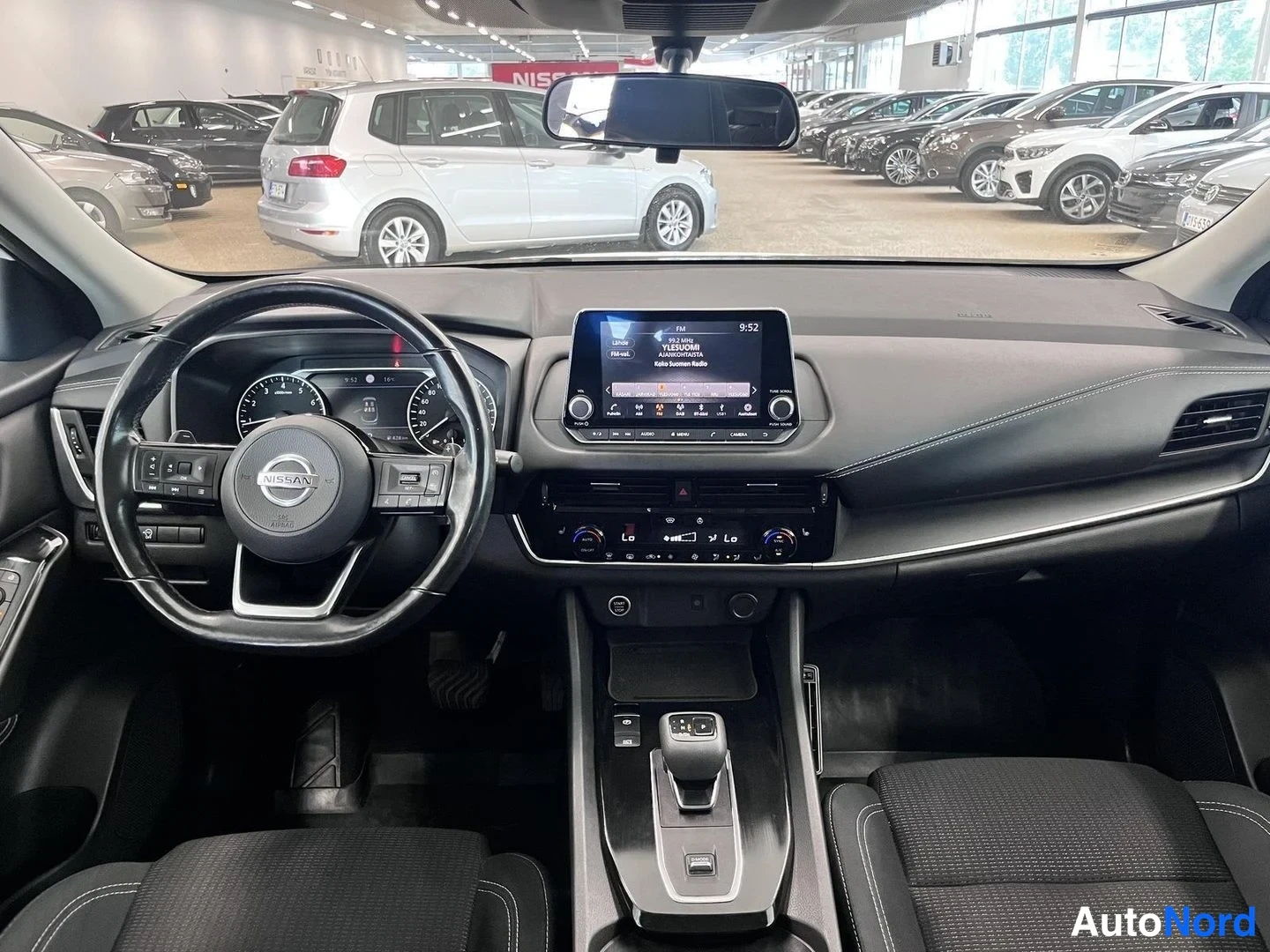 Muu: Nissan Qashqain ohjaamo kuljettajan puolelta: mittaristo, Nissan-ohjauspyörä, keskikäyttötaulu näytöllä ja vaihteenvalitsin.