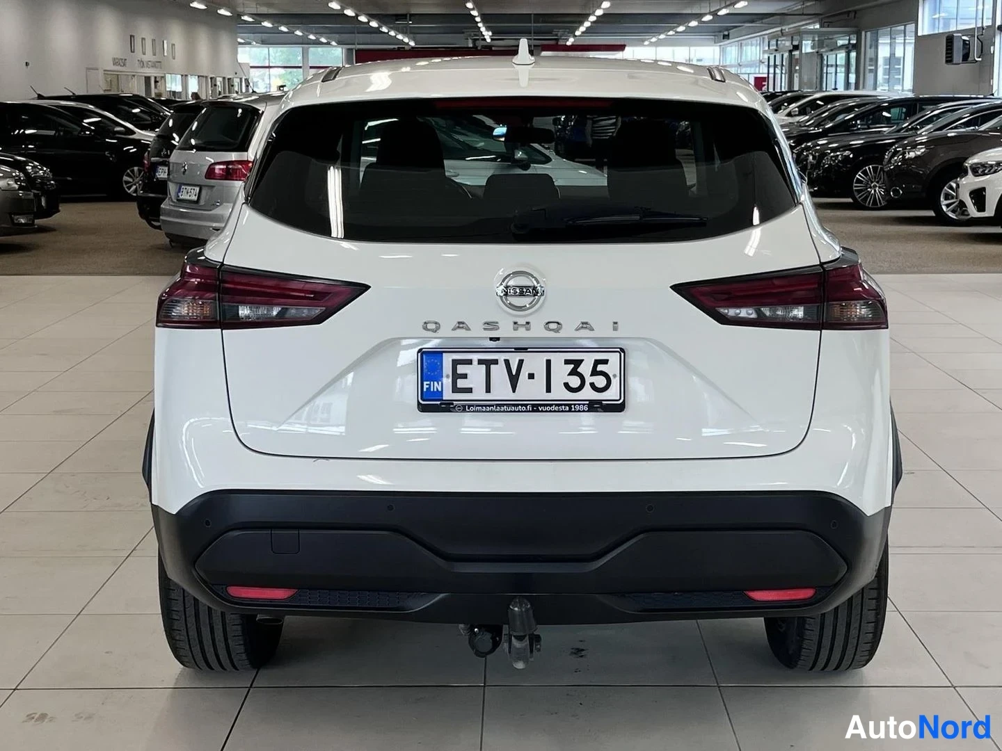Takaa: Valkoisen Nissan Qashqain suora takaotsikkokuva; QASHQAI-teksti ja rekisterikilpi, vetokoukku takapuskurissa.