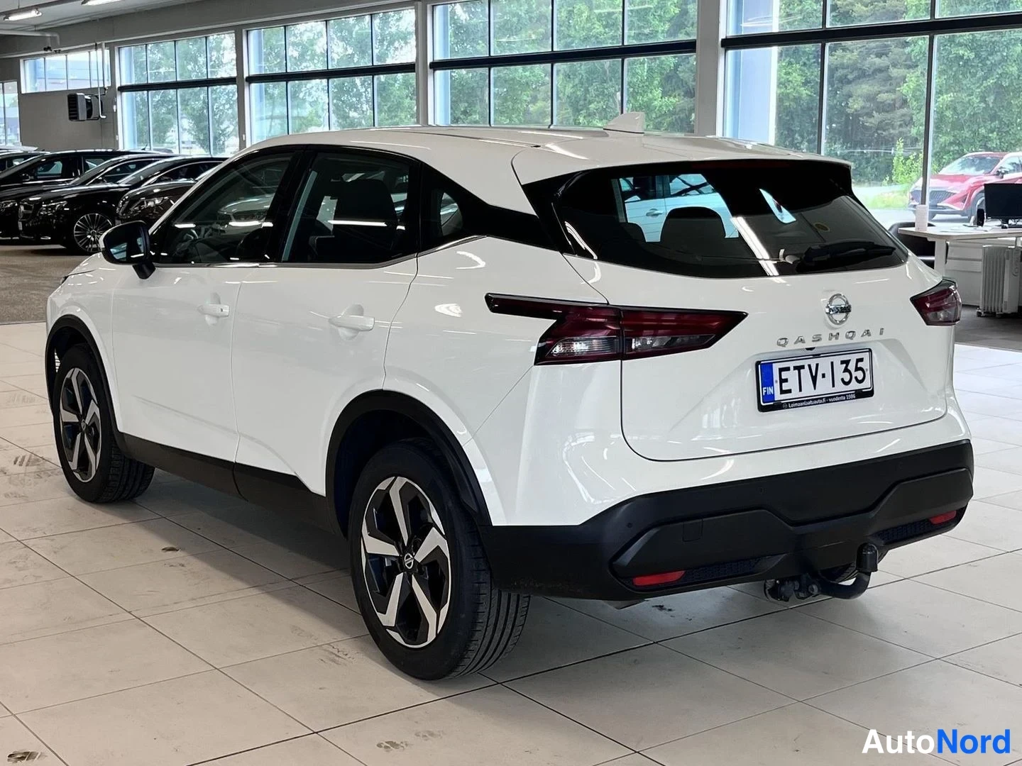 Takaviisto: Valkoisen Nissan Qashqain takakulman kuvakulma Autolle-korjaamon; rekisterikilpi, takavalo ja vetokoukku näkyvät.
