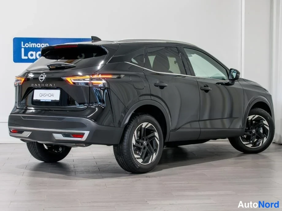 Takaviisto: Mustan Nissan Qashqain takakolmasosanäkymä sisätiloissa; takavalot, QASHQAI-teksti ja takapuskurin heijastimet näkyvät.