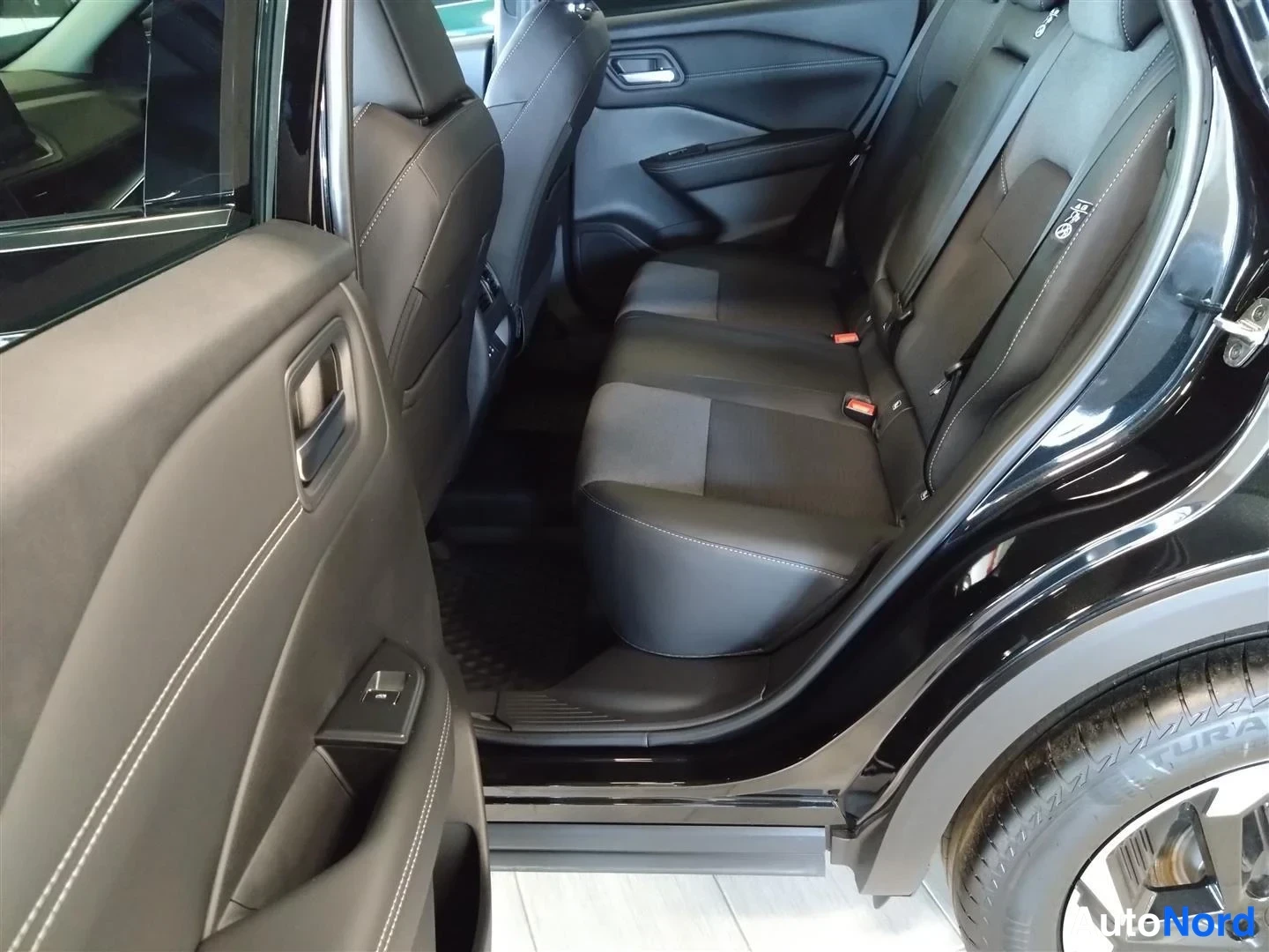 Muu: Nissan Qashqain takaistuimet mustaa kangasta, takamarin ja taakse jäävien etuistuinten takaa kuvattuna; takaoikea rengas osittain näkyvissä.
