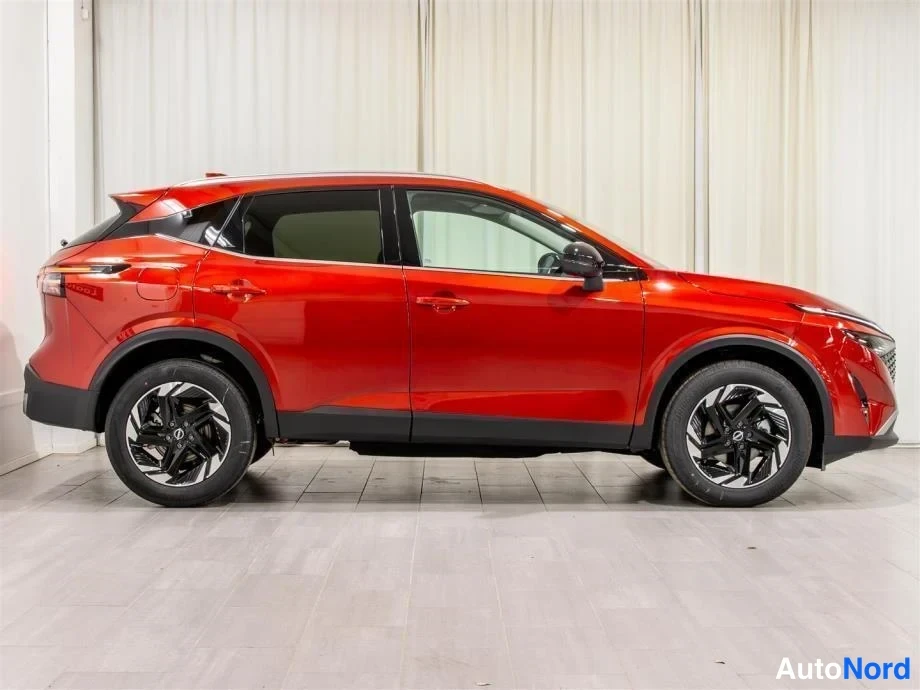 Etuviisto, nokka oikealle: Nissan Qashqai sivulta oikealta, punainen koripinta, mustat kevytmetallivanteet ja tummat ikkunat.