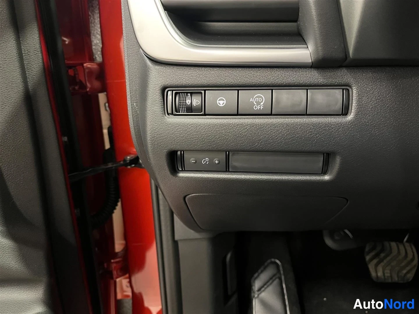 Yksityiskohta: Sisätilakuva: kojelaudan kytkimistö, jossa valaistuksen säädin, AUTO OFF -nappi ja sumuvalojen kytkimet.