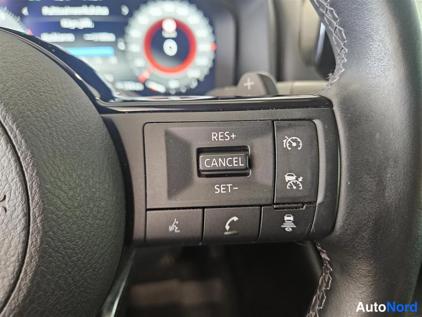 Muu: Lähikuva ohjauspyörän oikean reunan cruise control -painikkeista: RES+, CANCEL ja SET−.