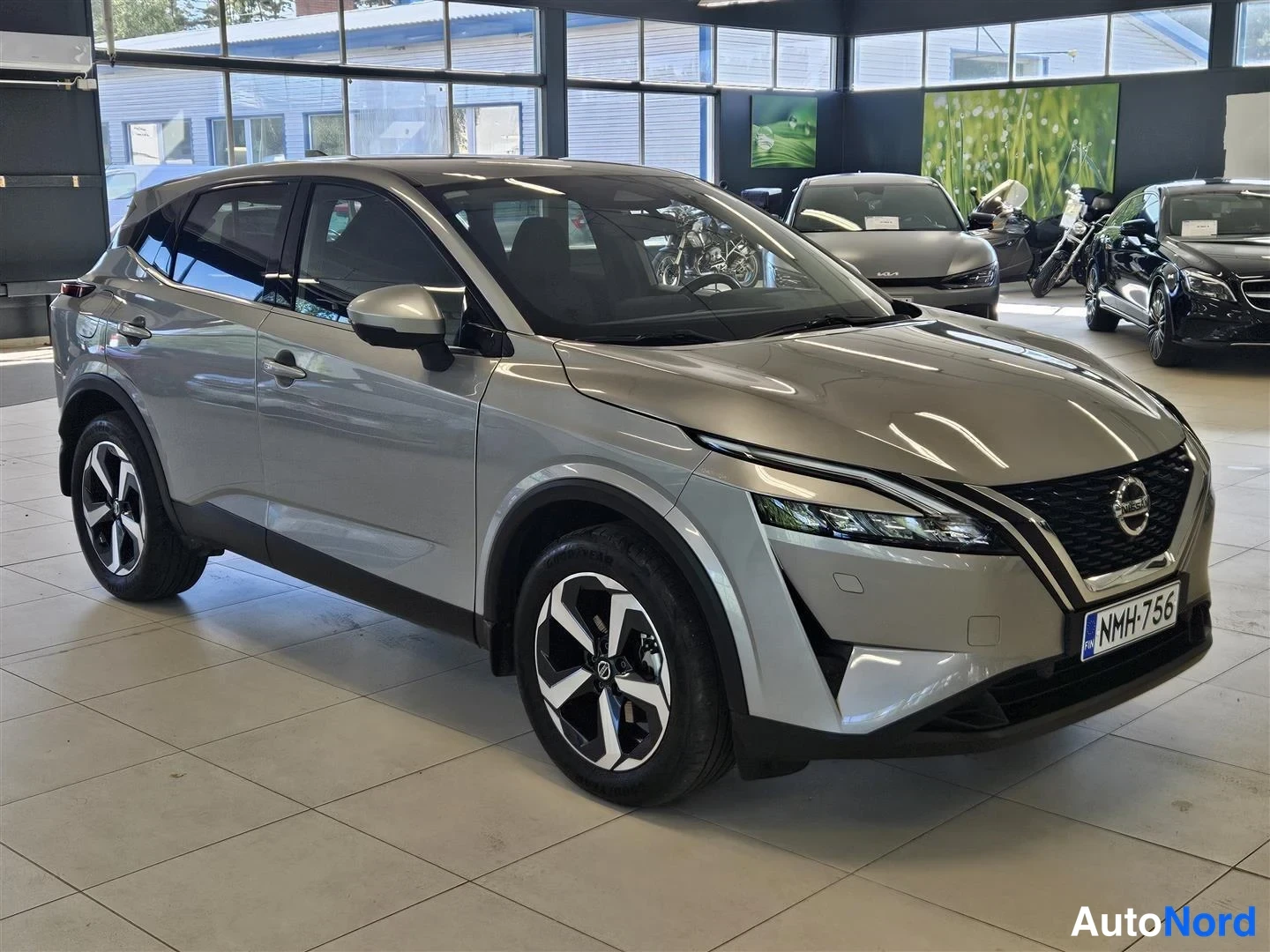 Etuviisto, nokka oikealle: Nissan Qashqai, etu-kolmannesnäkymä nenä oikealla; hopeinen crossover autosalonissa, rekisterikilpi.