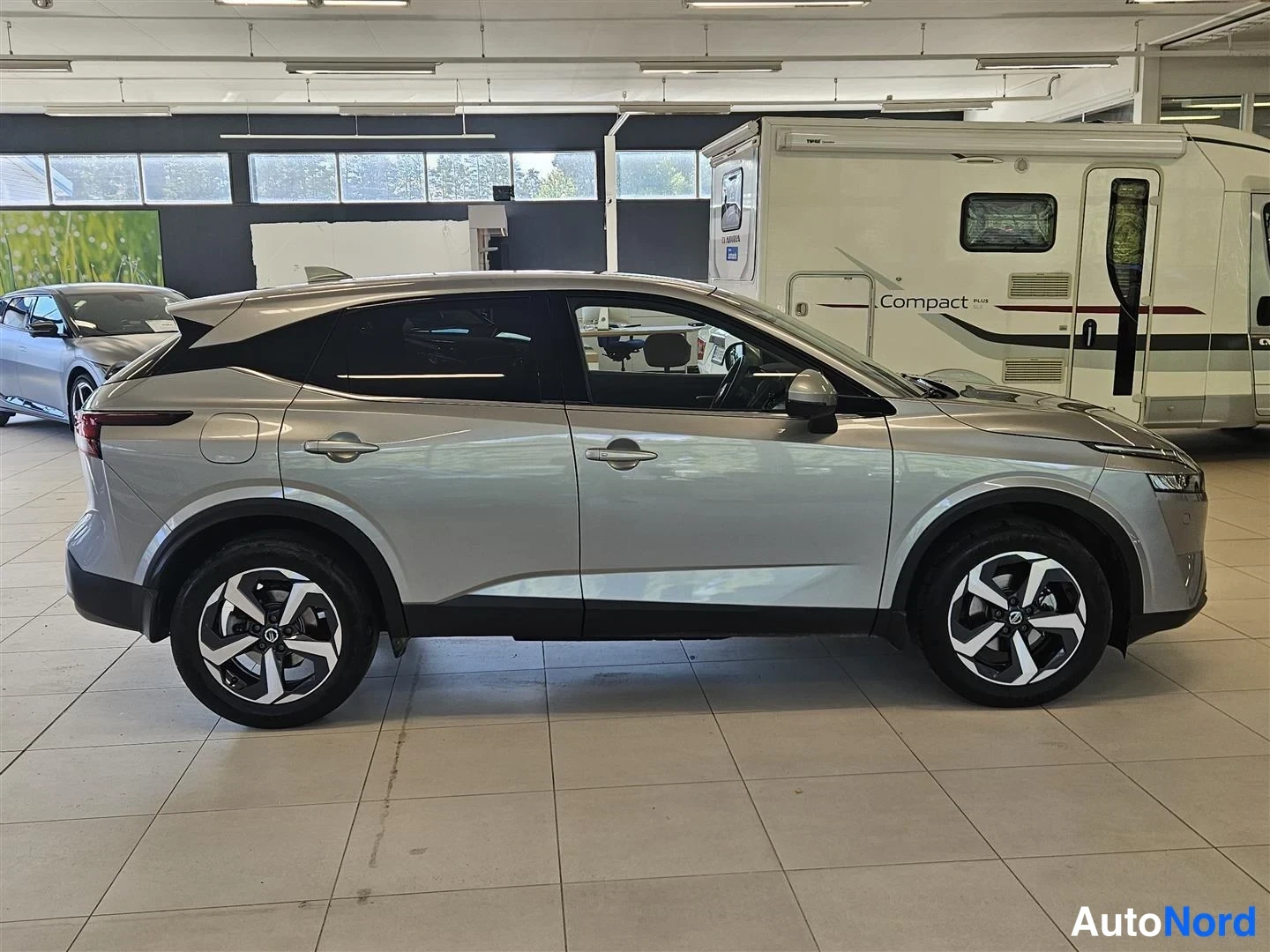 Sivulta: Nissan Qashqain sivunäkymä vasemmalta; hopeinen koripaneeli, neljä ovea, kevytmetallivanteet.